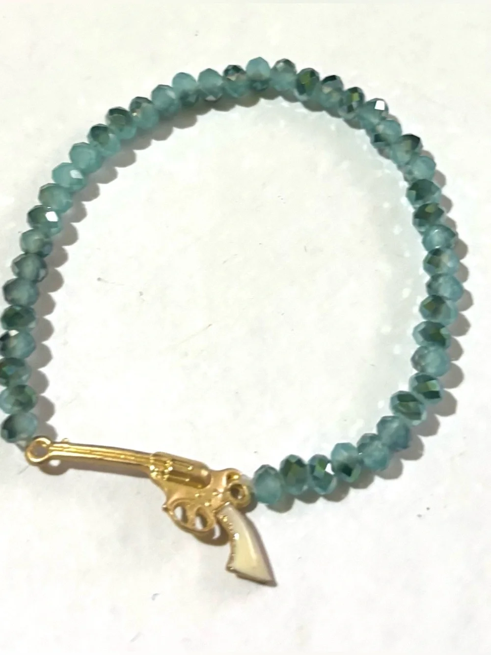 Teal Faceted Bead Stretch Bracelet with Gold Pistol Charm